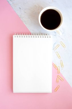 İş Işyeri kahve, defter ve altın kağıt klipleri bir fincan ile minimalist bir tarzda. Pembe ve mermer arka plan