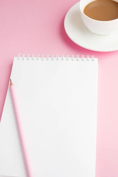 Defter, beyaz çarşaf, kalem, kahve. Pembe arka plan