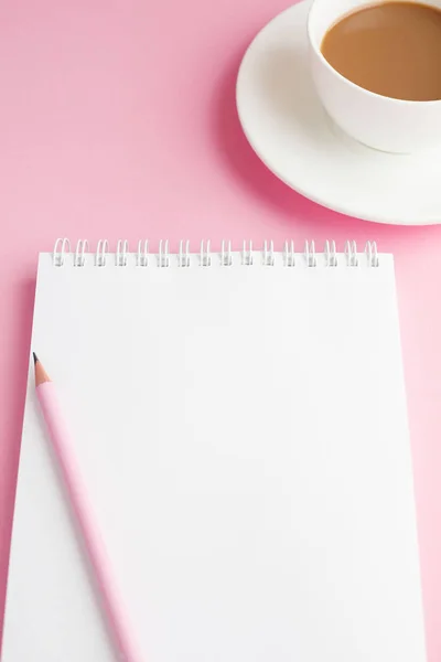 Defter, beyaz çarşaf, kalem, kahve. Pembe arka plan