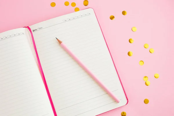 Defter, beyaz çarşaf, kalem. Pembe arka plan