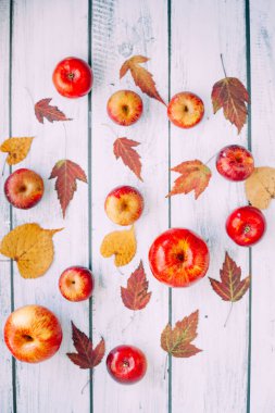 Kırmızı elma beyaz ahşap arka plan üzerinde izole bir demet