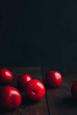 Kırmızı erik. Meyve. Karanlık arka plan. Ahşap. 