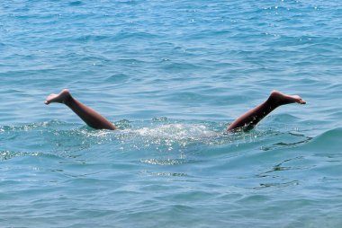 Dalış lı bir insanın bacakları denizde sudan görülebilir..                             