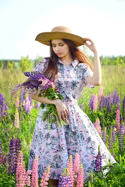 Young Beautiful Girl Hat Pink Dress Stands Lupine Field Looks — Stock Photo, Image