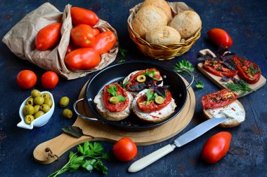 Mutfakta kurutulmuş domatesli, peynirli, zeytinli ve fesleğenli sandviç pişirmek. İtalyan kahvaltı konsepti