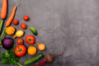 Domates, salatalık, patlıcan, soğan, havuç ve pancar, maydanoz. Tasarım için arka planda gri bir alan. Mevsimlik sebzeler. Yukarıdan görüntüle