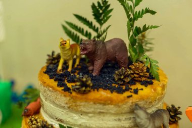 bir ayı kurt ve koni ler ve canlı yeşil eğrelti otu hayvan figürleri ile orman tarzı pasta. Tatlı bir masada beyaz krema ile Çıplak kek