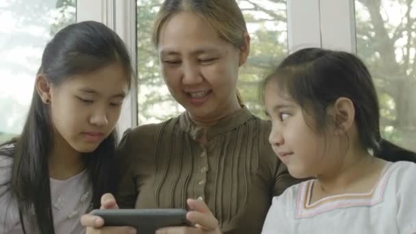 亚洲妇女与女儿在智能手机上玩游戏 一起快乐时光 — 图库视频影像