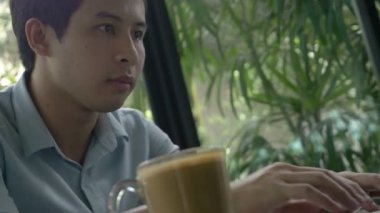 4k: kahve kafede dizüstü bilgisayar kullanan genç Asya iş adam