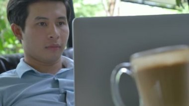 4k: Asyalı Genç iş adamı sıkılmış önünde laptop