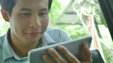 4k: Asyalı Genç adam kanepede oturan ve tablet pc kullanarak atış Pan