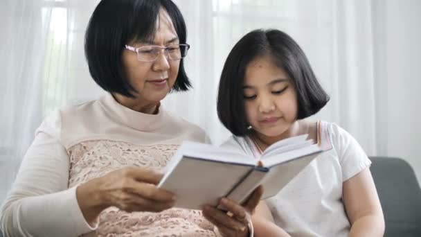 Ευτυχισμένη Γιαγιά Ασίας Και Όμορφη Κοπέλα Διαβάζοντας Βιβλίο Μαζί Στο — Αρχείο Βίντεο