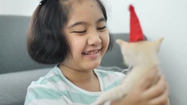 Santa Claus şapka yavru kedi kafasına mutlu Asyalı kız süsle