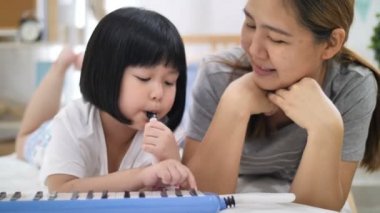 4k Melodika darbe organ oynarken mutlu küçük Asyalı kız