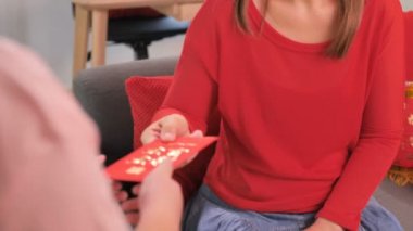 Asyalı kadın mutlu Çin Yeni Yılı kutlamaları çocuklarda kırmızı cep zarf vermek