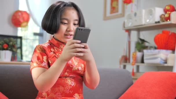 スローモーション 幸せなアジアの女の子用スマート フォン ビデオ呼び出し彼女の家族は 中国の新年のお祝いと — ストック動画