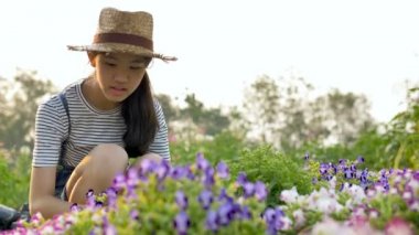 4k güzel Asyalı kız ağır çekim çekim bahçede çiçek dikim