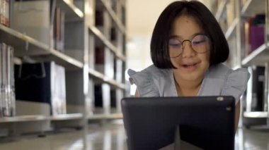 4 k Asya öğrenci dijital tablet okul kütüphanesinde ilham için çekim Dolly kullanma.