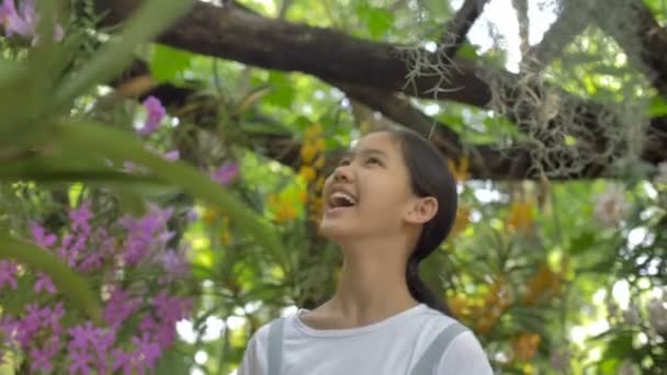 Счастливая Азиатская Девочка Наслаждается Цветущими Цветами Летнем Саду Солнечный День — стоковое видео