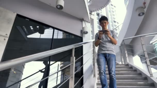 笨重的亚洲男子从楼梯上摔下来 通过使用智能手机的事故 — 图库视频影像