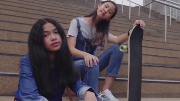 階段でスケートボードで微笑むヒップスターの若い女の子の肖像画 60Fps — ストック動画