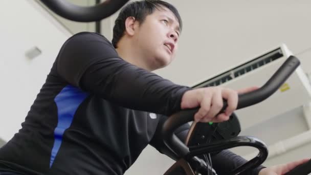 Asijský Tlustý Muž Který Pokouší Cvičit Cyklistickým Strojem Fitness Tělocvičně — Stock video
