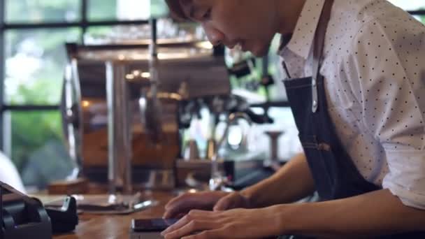 コーヒーカフェでコーヒーを作る際に仕事でアジアのバリスタをクローズアップ タブレットコンピュータで注文を受け取ります — ストック動画