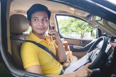 Genç Asya Teslimat adam deliveri için müşteriye telefon arama