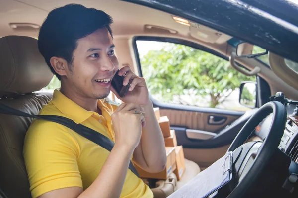 Junger asiatischer Liefermann telefoniert mit Kunde für Lieferung — Stockfoto