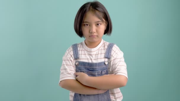 緑のクロマキーの小さなアジアの女の子は まっすぐ前方を見て 深刻な顔 腕を交差 — ストック動画