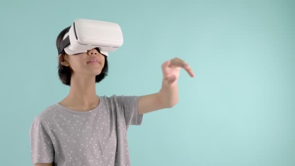 Азиатка Очках Виртуальной Реальности Играет Виртуальную Игру Синем Зеленом Фоне — стоковое видео