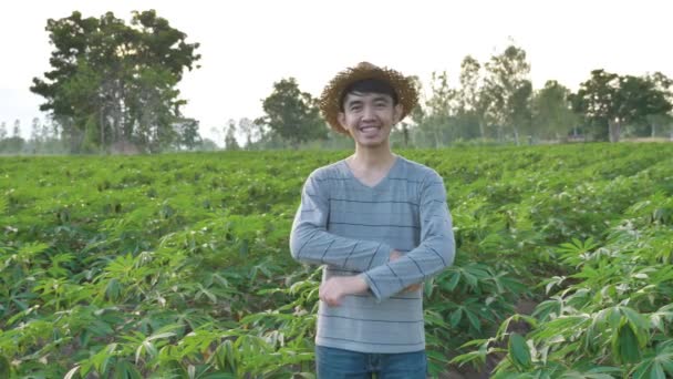 ドリーはキャッサバ畑で微笑む幸せな若いアジアの農家の肖像画を撮影しました スローモーション — ストック動画