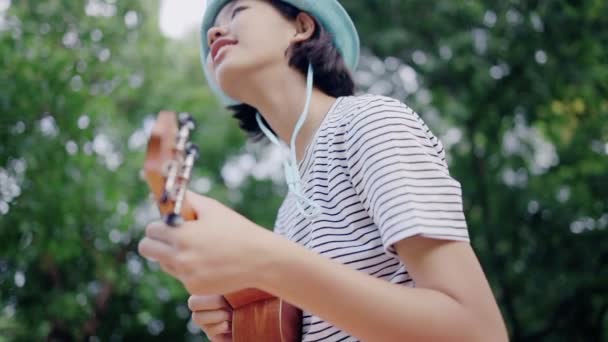 Vacker Asiatisk Tonårs Flicka Spelar Ukulele Parken Slow Motion — Stockvideo