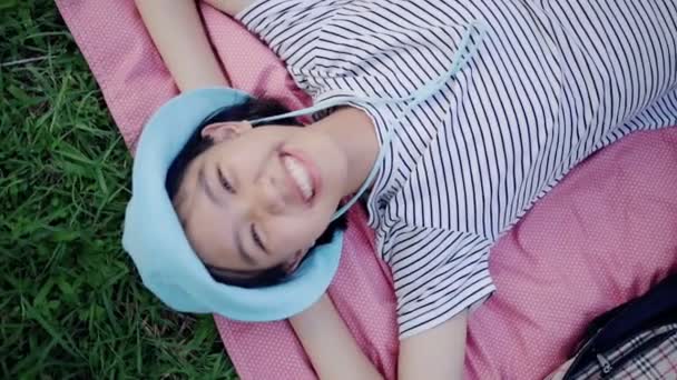 美丽的亚洲青少年女孩躺在草地上和梦想 享受自然 关闭慢动作 — 图库视频影像