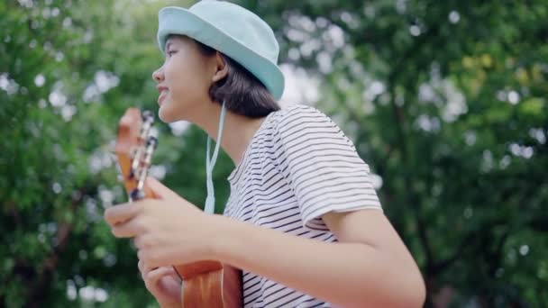 Vacker Asiatisk Tonårs Flicka Spelar Ukulele Parken Slow Motion — Stockvideo