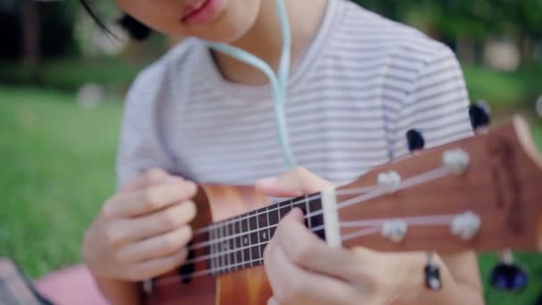 Linda Menina Adolescente Asiática Jogando Ukulele Parque Câmera Lenta — Vídeo de Stock