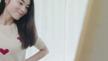 Asya Güzel kadın aynanın önünde yeni giysiler çalışıyor, Yavaş hareket