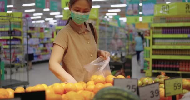 Slow Motion Shot Mujer Asiática Eligiendo Naranja Estante Supermercado Departamento — Vídeo de stock