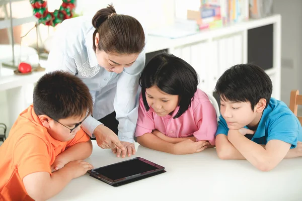 アジアの教師とデジタル タブレットを使用して自分自身を楽しませる 人の子供 — ストック写真