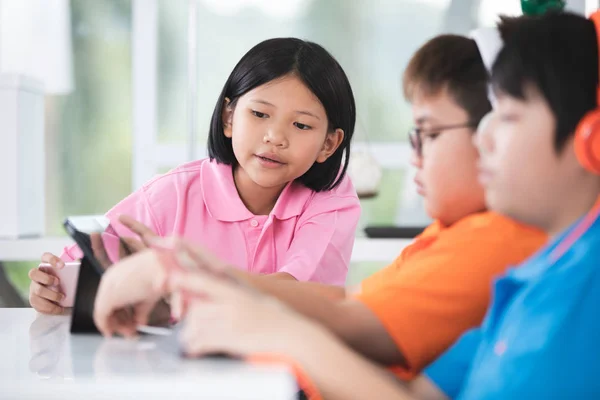 Asiatisk Barn Spiller Tablet Computer Sammen - Stock-foto