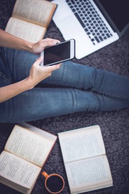 Oturma ve aygıtlarla, halı üzerinde rahatlatıcı kadın telefon, bilgisayar notebook ve laptop, yaşam tarzı ve ev iş kavramı