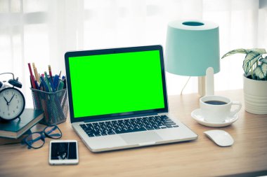 Çalışma alanı arka masada masaüstü pc ve ofis aksesuarları, dizüstü bilgisayar üzerinde yeşil ekran ile.