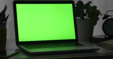 Yeşil ekran ile dizüstü bilgisayar. Karanlık ofisi. Dolly sağdan sola. Kendi resim veya video koymak için mükemmel.
