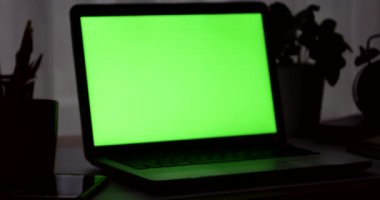 Yeşil ekran ile dizüstü bilgisayar. Karanlık ofisi. Dolly. Kendi resim veya video koymak için mükemmel.