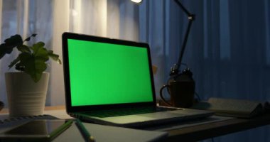 Yeşil ekran ile dizüstü bilgisayar. Karanlık ofisi. Dolly taşıma soldan sağa doğru. Kendi resim veya video koymak için mükemmel. Yeşil ekran teknolojisi kullanılıyor. Chroma anahtar laptop
