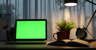 Yeşil ekran ile dizüstü bilgisayar. Karanlık ofisi. Dolly taşıma sağdan sola. Kendi resim veya video koymak için mükemmel. Yeşil ekran teknolojisi kullanılıyor. Chroma anahtar laptop