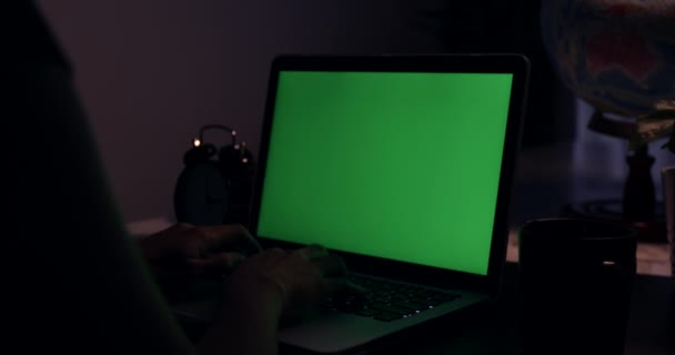 Sur la vue d'épaule de dactylographier et regarder sur l'ordinateur. Écran vert de la technologie utilisée. Chroma Key ordinateur portable .