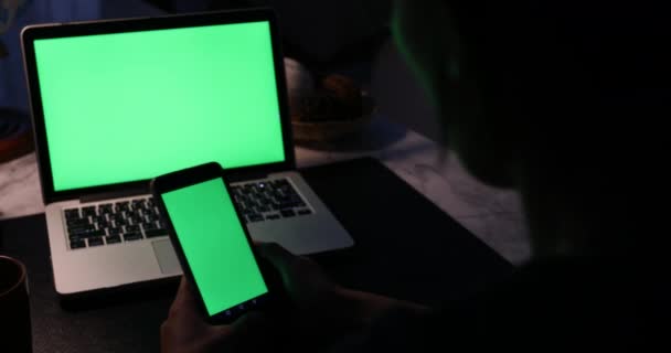 使用智能手机和带有绿色屏幕的笔记本电脑的手 多莉向右向左移动 — 图库视频影像