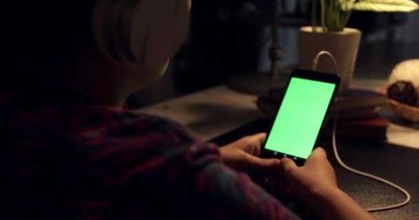 Au-dessus de la vue d'épaule du garçon asiatique utilisant un ordinateur tablette avec casque, écran vert de la technologie utilisée. Comprimé Chroma Key .