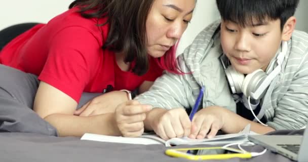 Asiática Madre Ayuda Joven Hijo Mientras Niño Está Haciendo Tarea — Vídeo de stock